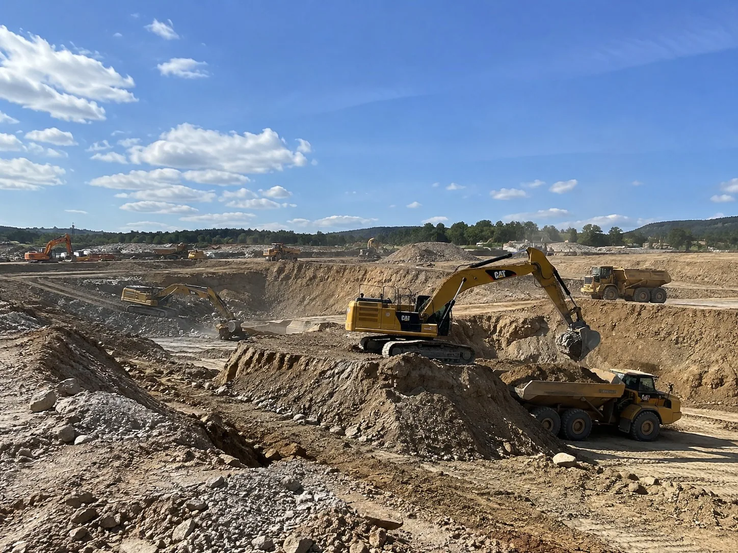 Excavator loading a dump truck on a large Auckland bulk earthworks site